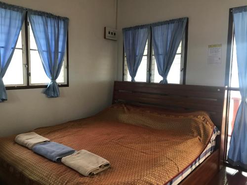 1 cama en un dormitorio con cortinas azules en ทับบีช เนเชอรัล รีสอร์ท 