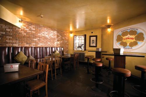 a bar with wooden tables and chairs and a brick wall at Hotel du Vin Birmingham in Birmingham