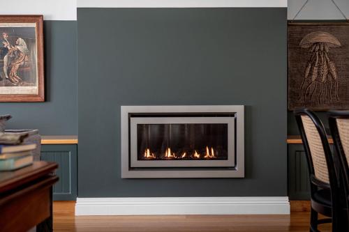 a fireplace against a blue wall with flames in it at Ship Inn Stanley in Stanley
