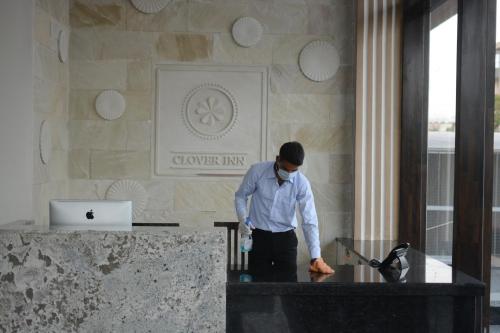a man standing at a desk in a lobby at Clover Inn in Udaipur