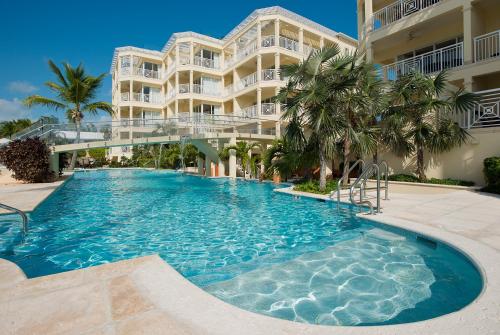 a swimming pool in front of a building at Windsong on the Reef in Grace Bay