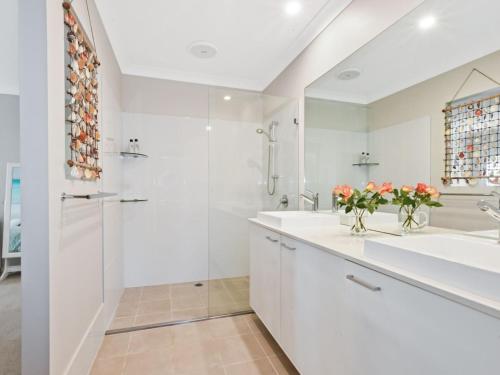a white bathroom with a sink and a shower at Sun Daze at Smithies in Smiths Lake
