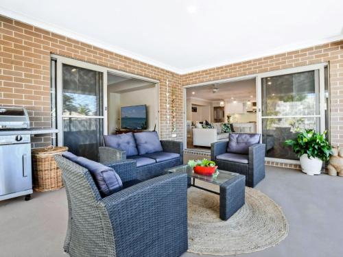 a patio with two couches and a table at Sun Daze at Smithies in Smiths Lake