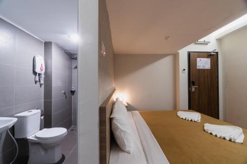 y baño con cama, aseo y lavamanos. en Urban Inn, SP Saujana, en Sungai Petani