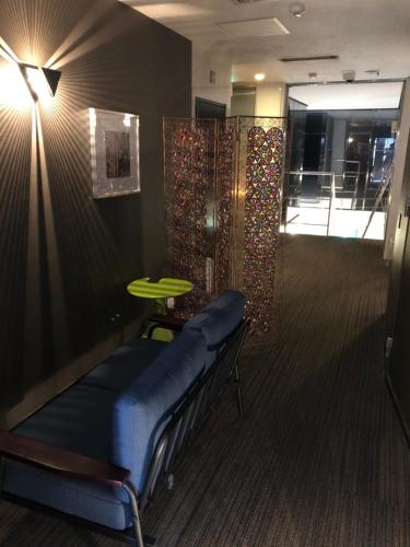 a waiting room with a blue bench and a table at Hotel Patio in Hiroshima
