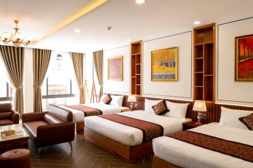 ダラットにあるLa Fleur Premium Central Apartment Hotelのベッド3台とソファが備わるホテルルームです。