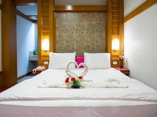 a white bed with a heart made out of flowers at โรงแรมศิริโฮเต็ล Sirihotel Korat in Nakhon Ratchasima