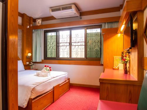 a small bedroom with a bed and a window at Siri Hotel in Nakhon Ratchasima