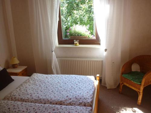 a bedroom with a bed and a window and a chair at Elegant in Gross Kordshagen amidst lush greenery with garden in Groß Kordshagen