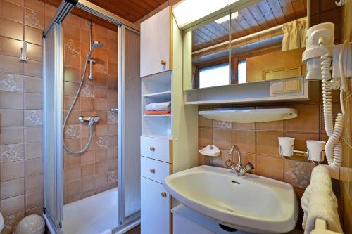een badkamer met wastafel en douche bij Ferienhaus Kröll in Ellmau