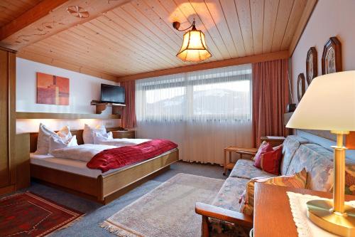 een slaapkamer met een bed en een bank in een kamer bij Ferienhaus Kröll in Ellmau