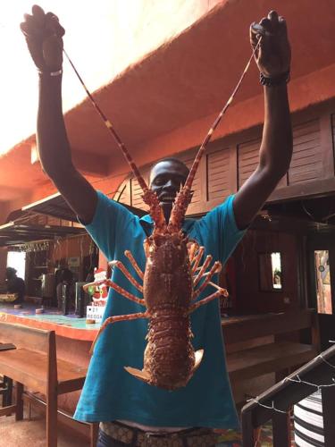 a man holding a lobster on a rope at La Cabane du Pêcheur Atlantic Evasion in Dakar