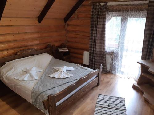 a bedroom with a bed in a log cabin at Guest House Dikiy Zrub in Vorokhta