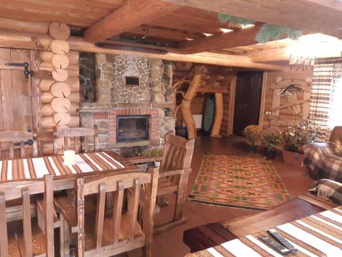 ボロフタにあるGuest House Dikiy Zrubの石造りの暖炉と木製家具付きのリビングルーム
