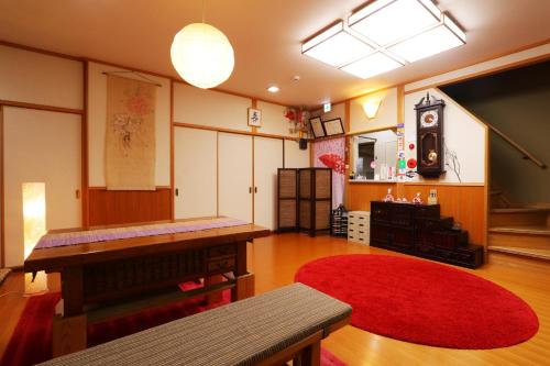 a living room with a red rug and a table at Miyoshino Sakuraan in Yoshino