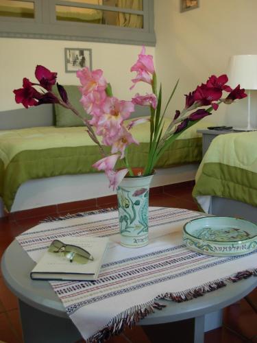 a table with a vase with pink flowers on it at DIMITRIOS in Skiros