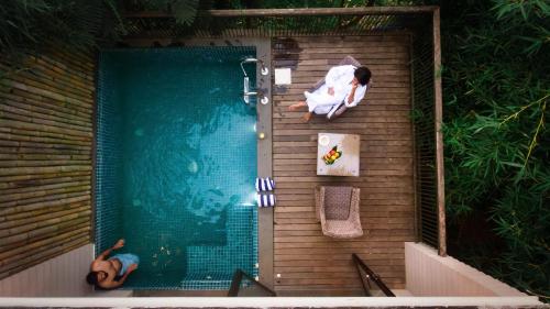 Eine Frau, die am Rande eines Schwimmbads liegt. in der Unterkunft Morickap Resort in Vythiri