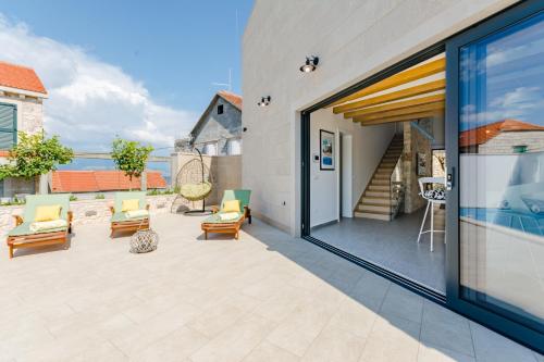 an outdoor patio with chairs and a sliding glass door at Villa Stone Pearl in Sutivan