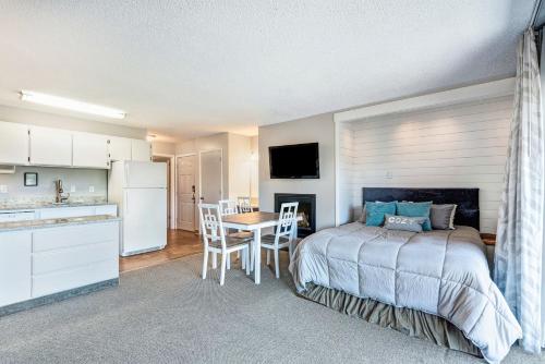 a bedroom with a bed and a table and a kitchen at Bend Riverside Condos Near Downtown Bend in Bend