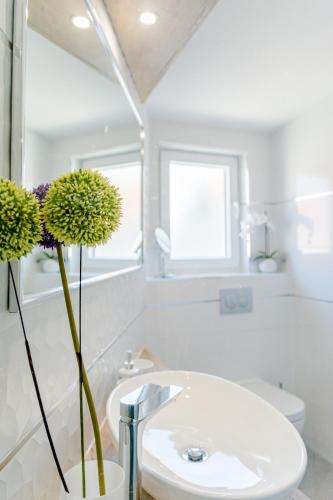 a white bathroom with a sink and a toilet at Villa Stone Pearl in Sutivan