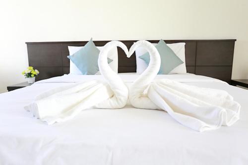 a white bed with two swans forming a heart at วีรวรรณ เพลส Weerawan Place in Khon Kaen