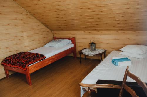 - une chambre avec 2 lits dans une cabane en bois dans l'établissement Cabana Săcuieu Vlădeasa, à Săcuieu