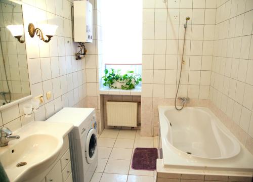 ein weißes Badezimmer mit einer Badewanne und einem Waschbecken in der Unterkunft Kashtan guest house in Kiew