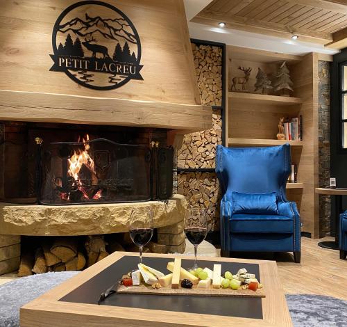 a lobby with a fireplace and a table with wine glasses at Hotel Petit Lacreu in Salardú