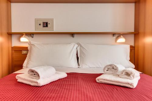 a bed with towels on top of it at Casa Portofino Rooms&Breakfast in Cesenatico