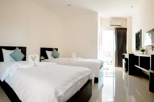 孔敬的住宿－วรรณ เพลส Won Place，酒店客房,配有两张带白色床单的床