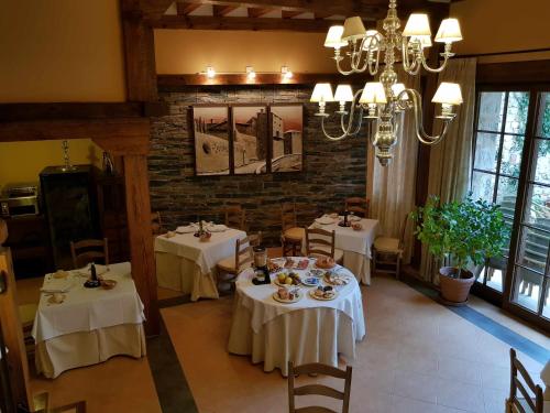 a dining room with two tables with white table cloth at Hosteria del Arco in Pedraza-Segovia