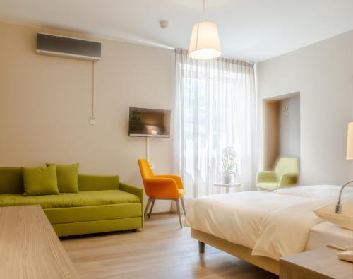 a bedroom with a bed and a couch at Hotel Unione in Bellinzona