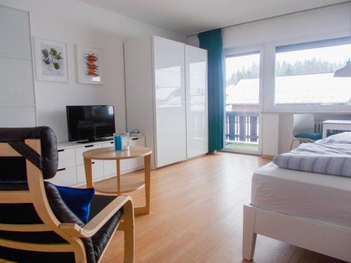 um quarto com uma cama, uma televisão e uma mesa em Nebelhorn Appartement 207 em Oberstdorf