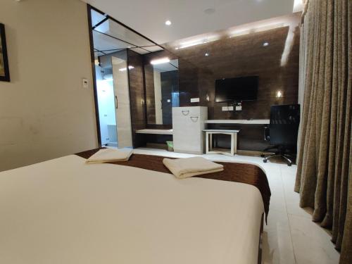 a large white bed in a room with a kitchen at Neermala Residency in Coimbatore