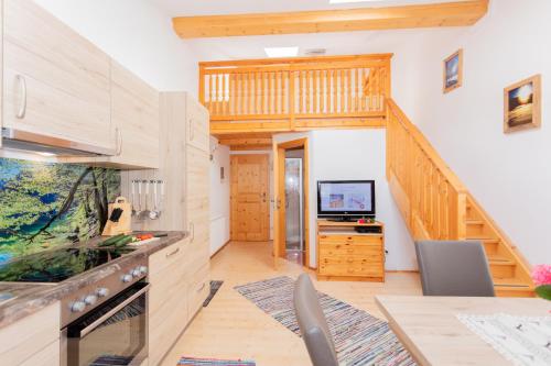 a kitchen with a staircase and a living room at Frühstückspension Müllergut in Sankt Martin bei Lofer