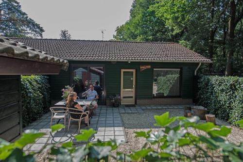 two people sitting at a table outside a green house at Vakantiepark Zevenbergen in Heesch