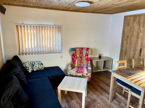 a living room with a blue couch and a table at EDER- Penzion & Apartmány in Horní Planá