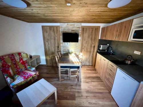a living room with a table and a couch and a kitchen at EDER- Penzion & Apartmány in Horní Planá