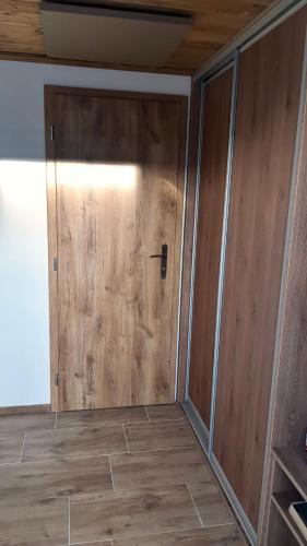 a wooden door in a room with a wooden floor at EDER- Penzion & Apartmány in Horní Planá