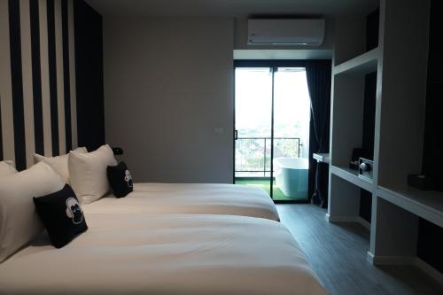 Ein Bett oder Betten in einem Zimmer der Unterkunft Blu Monkey Hub and Hotel Chanthaburi