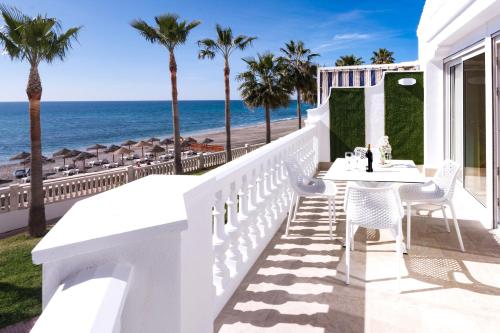 a white balcony with a table and chairs and the ocean at Apartamentos Perla Marina in Nerja