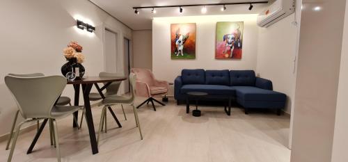 uma sala de estar com um sofá azul e uma mesa em Yuval holidey aprtment eilat em Eilat