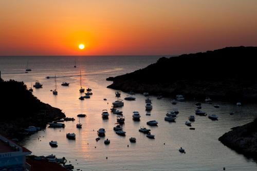 a group of boats in the water at sunset at Barceló Portinatx - Adults Only in Portinatx