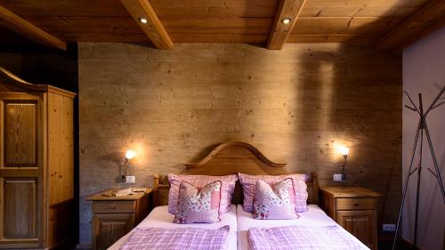 um quarto com uma cama grande e almofadas cor-de-rosa em Ferienwohnungen Ramslerhof em Ruhpolding