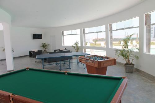 una mesa de billar en una habitación grande con ventanas en Casa 33 Sotavento Paracas en Paracas