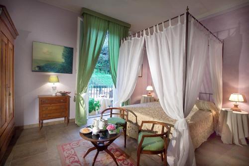 1 dormitorio con cama con dosel, mesa y sillas en B&B Monte Oliveto, en Florencia