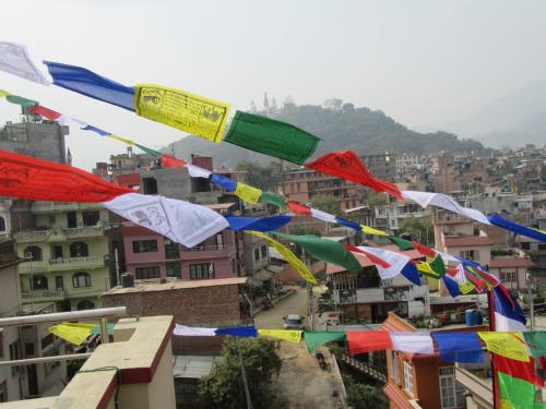 a bunch of prayer flags flying over a city at STUPA VIEW INN in Kathmandu