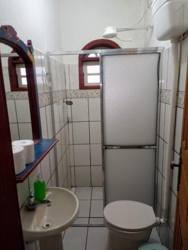 a small bathroom with a toilet and a sink at Pouso Jequitibá in Tiradentes