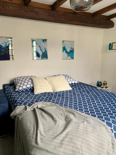- une chambre dotée d'un lit avec des draps bleus et blancs dans l'établissement Appartement les Bleuets - Centre ville de Saumur, à Saumur