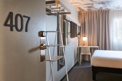 a hotel room with a bed and a table at ibis Clamart Paris Velizy in Clamart